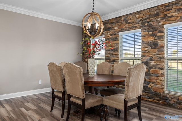 dining space featuring dark wood-type flooring, baseboards, a notable chandelier, and crown molding