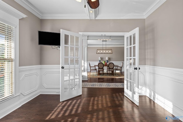 entrance foyer featuring french doors, crown molding, and a wainscoted wall