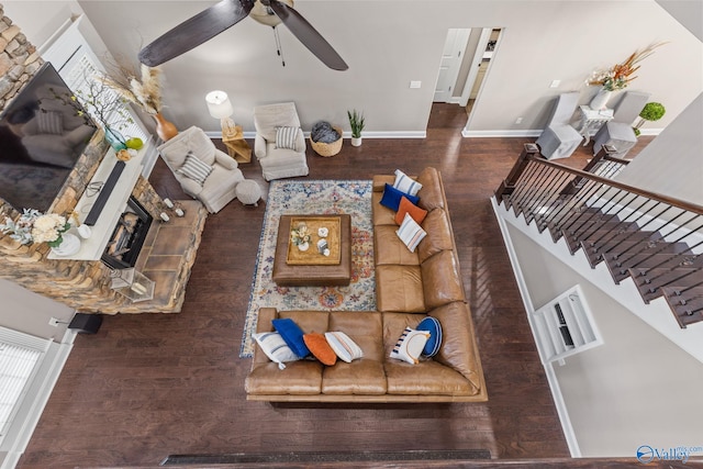 living room with baseboards, a ceiling fan, a fireplace, stairway, and wood finished floors