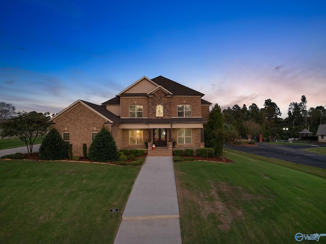view of front of house with a yard and brick siding