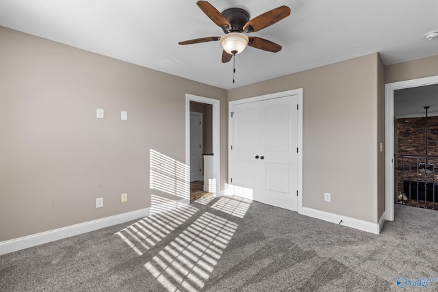 unfurnished bedroom featuring carpet, a closet, baseboards, and ceiling fan