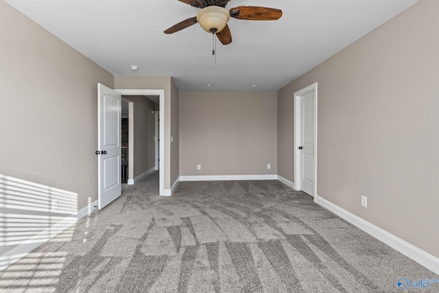 spare room with ceiling fan, carpet flooring, and baseboards