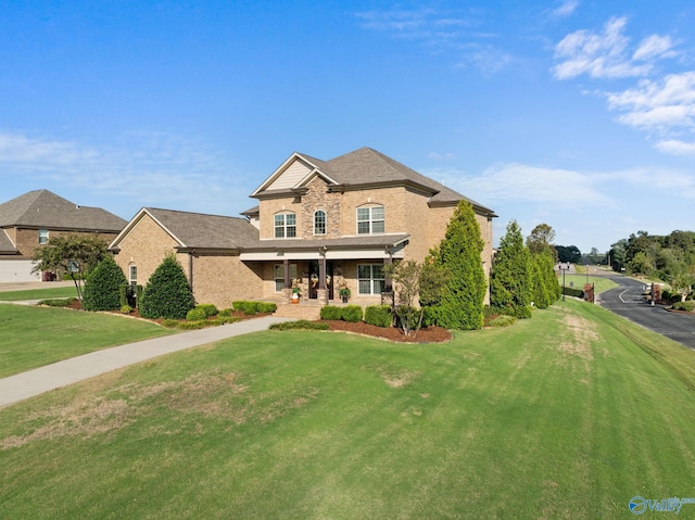 traditional-style home featuring a front yard and brick siding