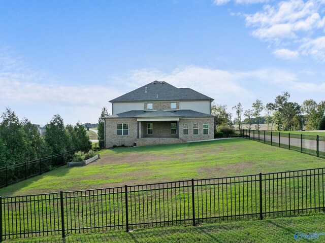 rear view of property with a yard and a fenced backyard
