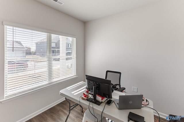 office space with hardwood / wood-style flooring and a healthy amount of sunlight