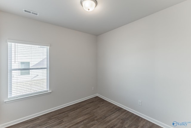 unfurnished room featuring a healthy amount of sunlight and dark hardwood / wood-style flooring