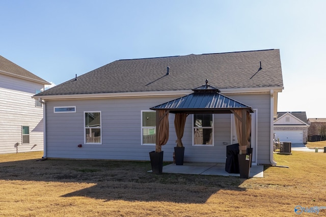 rear view of property with a gazebo, cooling unit, a patio, and a lawn