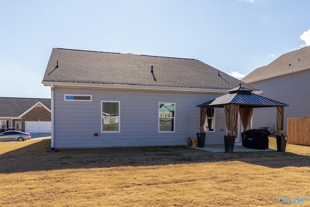 back of property with a gazebo, a yard, and a patio