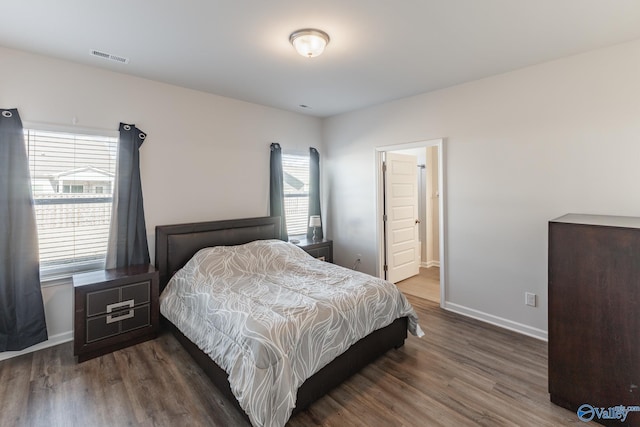 bedroom with dark hardwood / wood-style floors and connected bathroom