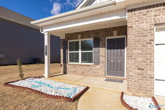 view of exterior entry featuring covered porch and cooling unit