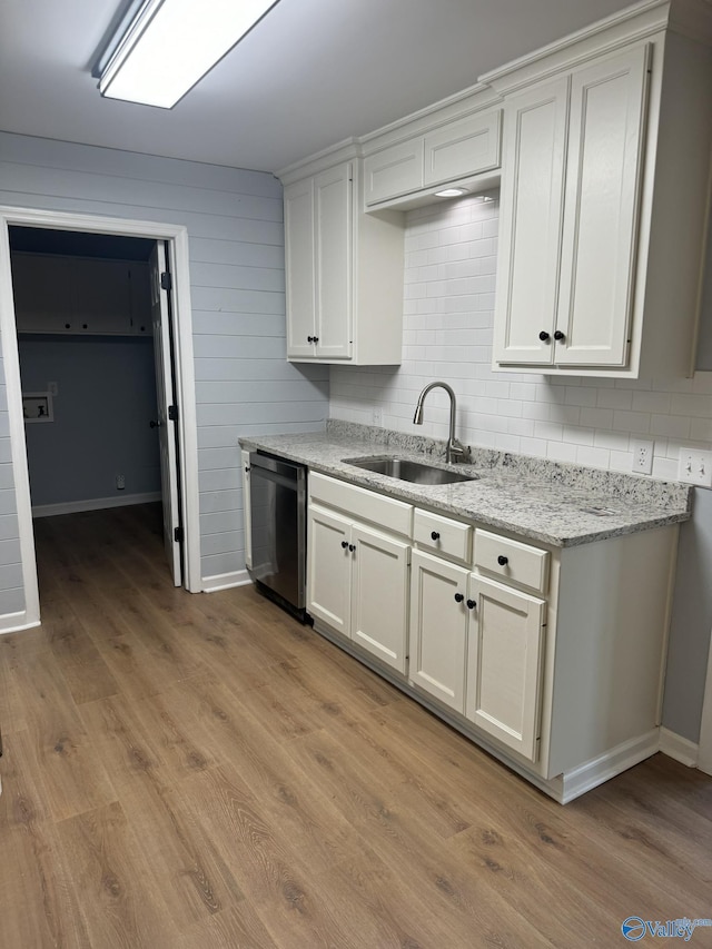 kitchen featuring dishwasher, sink, and white cabinets