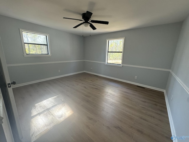 unfurnished room with ceiling fan and dark hardwood / wood-style flooring