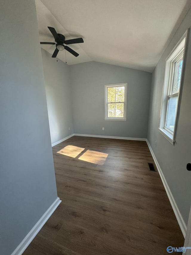 unfurnished room featuring dark hardwood / wood-style flooring and vaulted ceiling