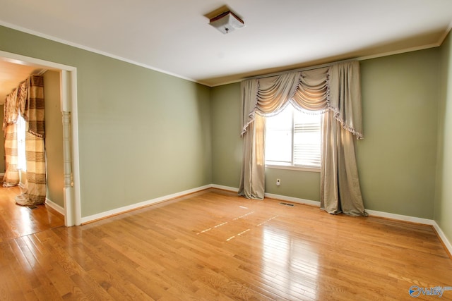 empty room with crown molding and hardwood / wood-style floors