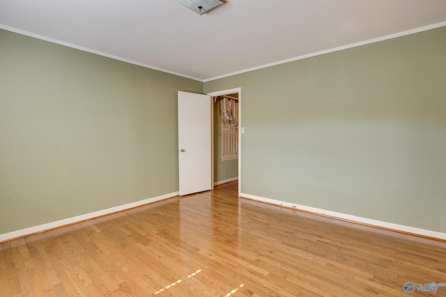 unfurnished room featuring crown molding and light hardwood / wood-style floors