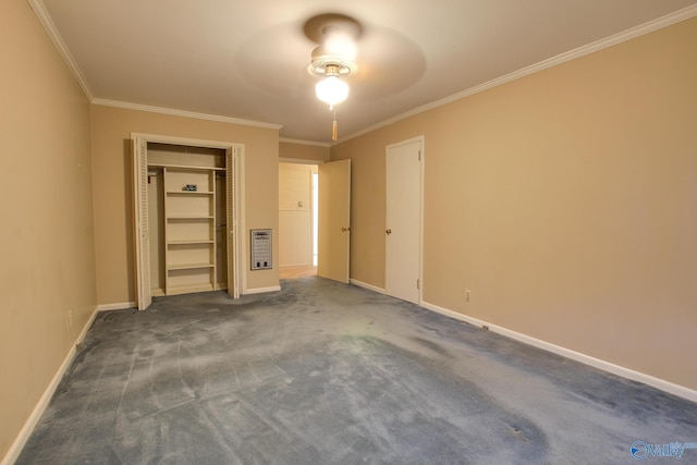 unfurnished bedroom with heating unit, crown molding, a closet, and dark colored carpet