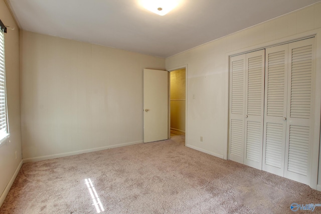 unfurnished bedroom with multiple windows, light colored carpet, and a closet