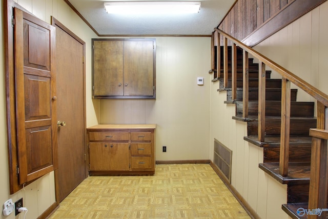 interior space featuring parquet floors, crown molding, and a textured ceiling