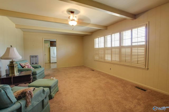 carpeted living room featuring heating unit, beam ceiling, and ceiling fan