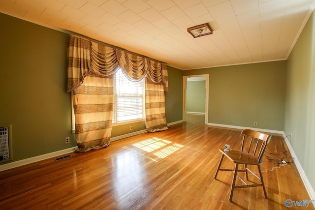 unfurnished room with hardwood / wood-style flooring and ornamental molding