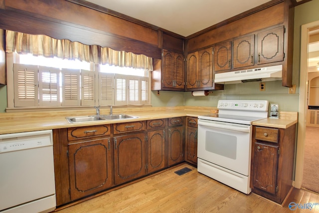 kitchen with white appliances, light hardwood / wood-style floors, and sink