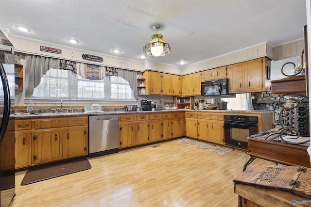 kitchen featuring sink, light hardwood / wood-style flooring, black appliances, a textured ceiling, and decorative light fixtures