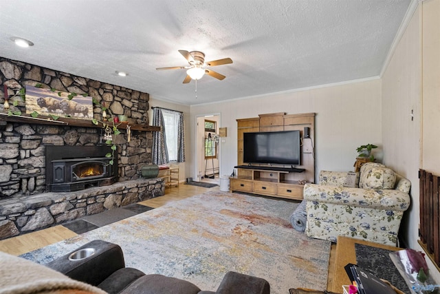 living room featuring ornamental molding, a fireplace, light hardwood / wood-style floors, and a textured ceiling