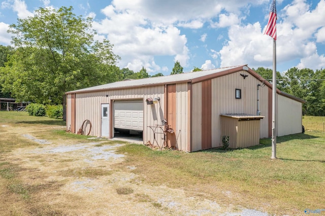 view of outdoor structure with a garage and a lawn