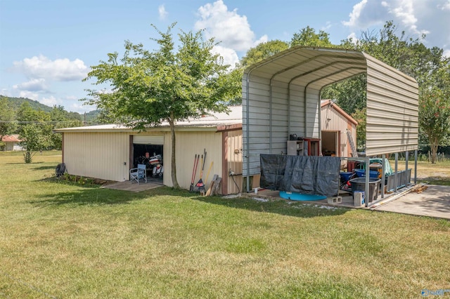 view of outbuilding with a lawn and a carport