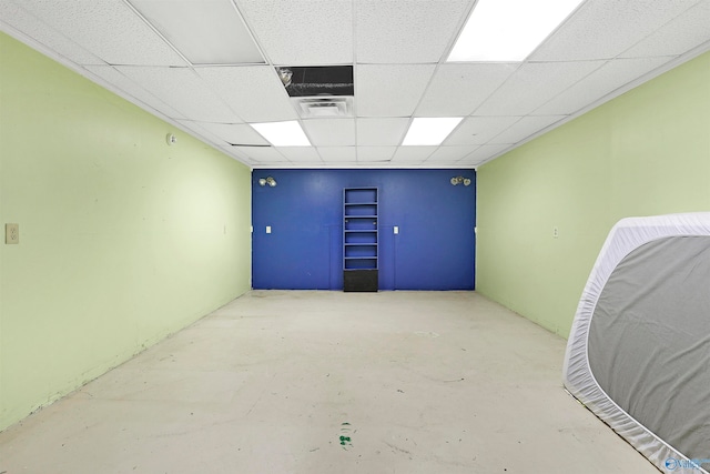 unfurnished room featuring a paneled ceiling and concrete flooring