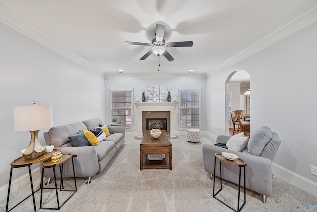 carpeted living room with crown molding and ceiling fan