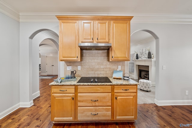 kitchen featuring light stone counters, tasteful backsplash, black electric cooktop, ornamental molding, and dark hardwood / wood-style flooring