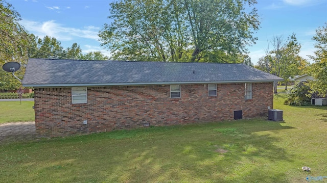 view of side of home featuring central AC and a yard