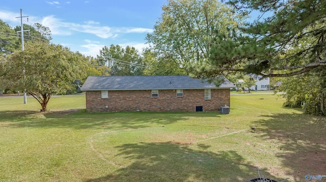 exterior space with central AC and a lawn