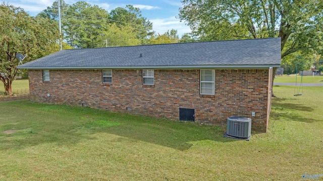 view of side of property featuring a yard and central AC unit