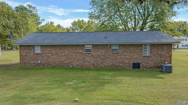 view of side of home with central air condition unit and a lawn