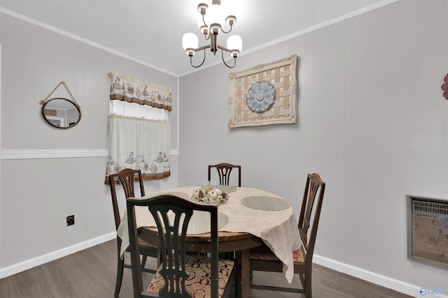 dining space featuring ornamental molding, dark wood-type flooring, heating unit, and a chandelier