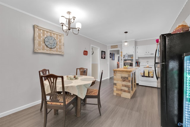 dining space with an inviting chandelier, crown molding, and light wood-type flooring