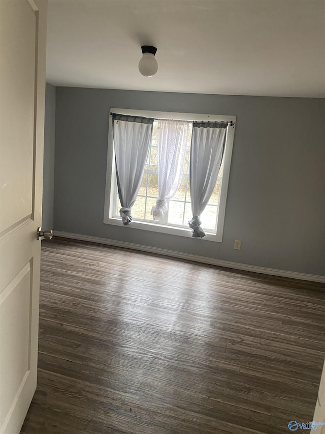 unfurnished room with dark wood-type flooring