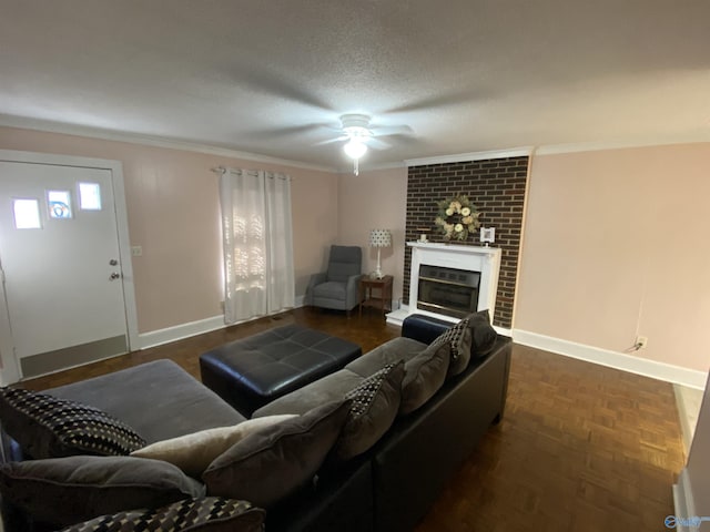 living room featuring a fireplace, a textured ceiling, ornamental molding, dark parquet flooring, and ceiling fan