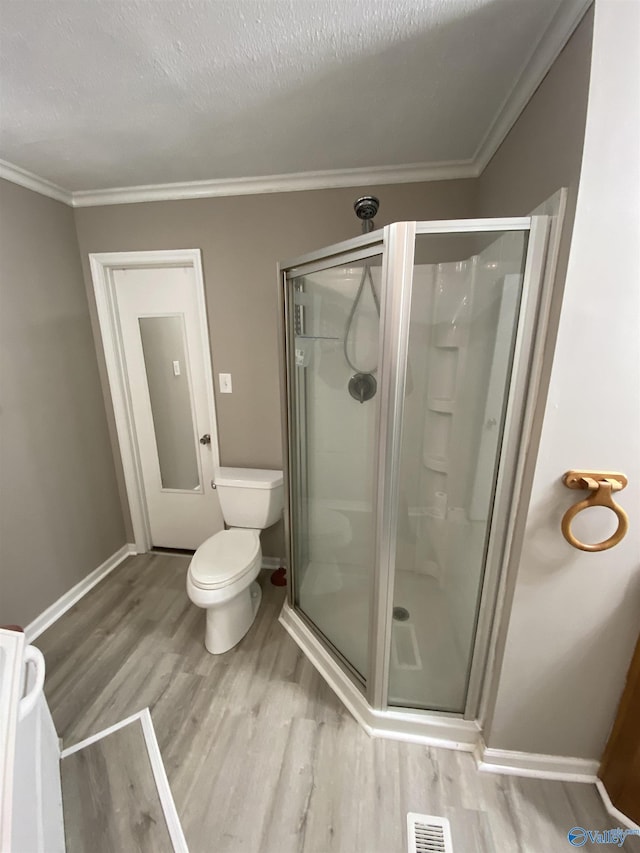 bathroom with hardwood / wood-style floors, a textured ceiling, walk in shower, and ornamental molding