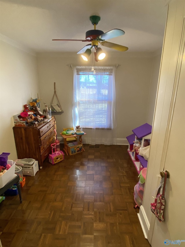 game room with dark parquet floors and ceiling fan