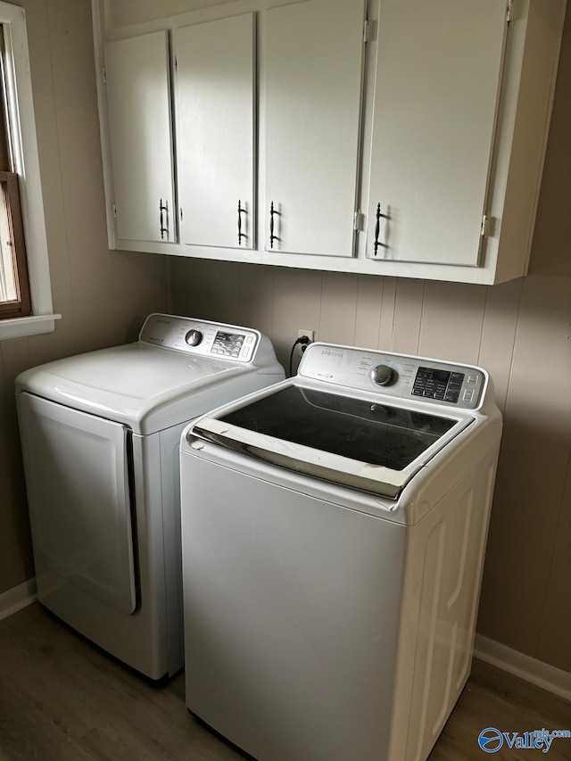 washroom featuring cabinets, dark hardwood / wood-style floors, and washer and clothes dryer