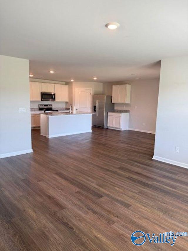 196 Murphy Ln, Madison, AL 35756 - unfurnished living room featuring baseboards, dark wood-style floors, recessed lighting, and a sink