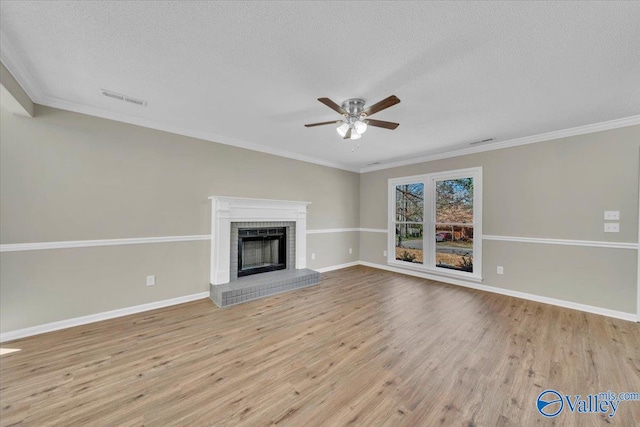 unfurnished living room with wood finished floors, a textured ceiling, baseboards, visible vents, and ceiling fan