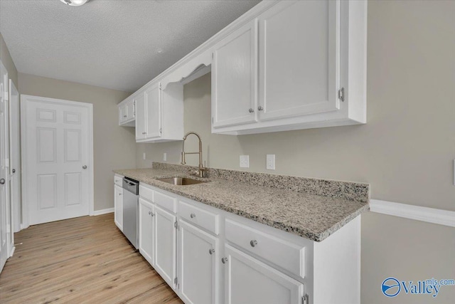 kitchen featuring white cabinets, a sink, and dishwasher