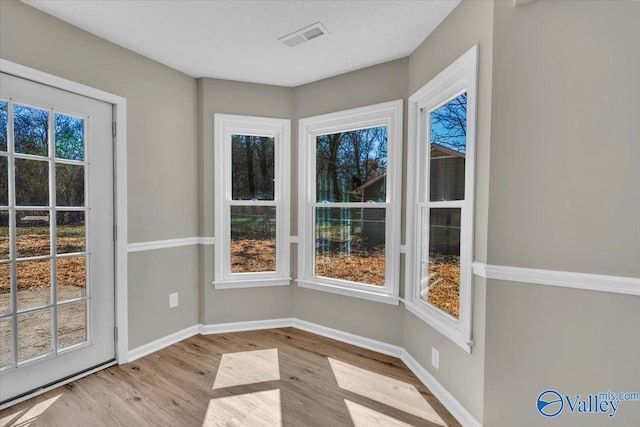 interior space featuring baseboards, visible vents, and wood finished floors