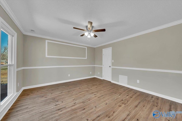 unfurnished room with wood finished floors, ornamental molding, baseboards, and ceiling fan