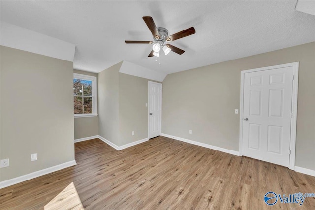 empty room featuring a ceiling fan, baseboards, and wood finished floors