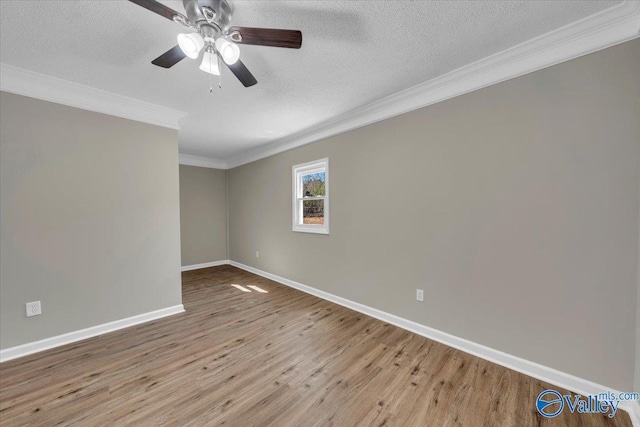 empty room with baseboards, wood finished floors, ornamental molding, and a textured ceiling